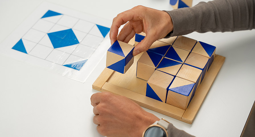 Bild einer Patientin im Hirnleistungtraining der Ergotherapie, die ein Block-Puzzle löst.